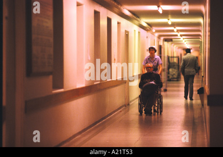A nurse with a patient in a wheelchair at Whipps Cross Hospital, London, UK Stock Photo
