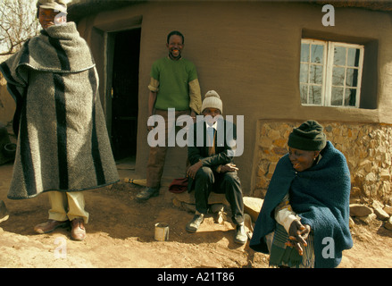 A group of men and women socialising outside a village house,  Lesotho, Southern  Africa Stock Photo
