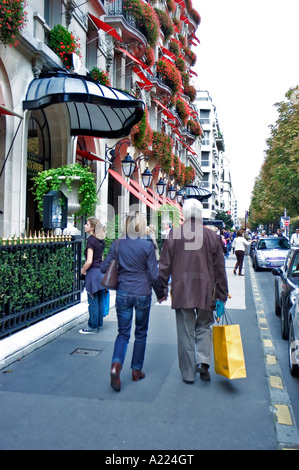 Paris France, Couple Walking Away, Carrying Shopping Bags Luxury Shops on 'Avenue Montaigne' Parisian Street Scene 'Hotel Plaza Athenée' Stock Photo