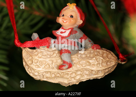 Santa on a peanut christmas decoration hanging in a pine tree Stock Photo