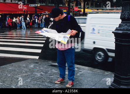 France Paris Young Adult Tourist Looking at a Map of the City Stock Photo