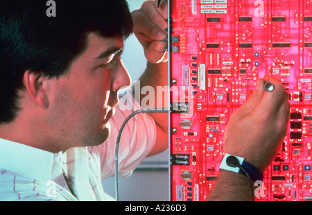Cellular telephone technician at work on circuit board in Syracuse New York Stock Photo