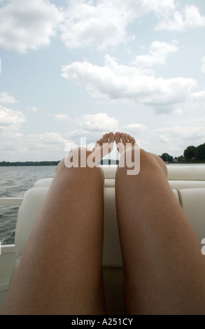 Woman with long legs reclining on boat Stock Photo