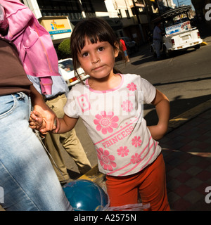 Girl affecting a pose holds her mother's hand on the streets of downtown Mazatlan Mexico Stock Photo