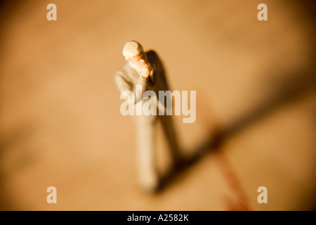 Miniature businessman with hand on chin standing on financial newspaper Stock Photo