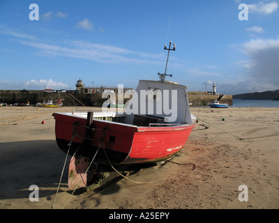 Small red fishing boat on the sands St. Ives harbour West Cornwall UK Stock Photo