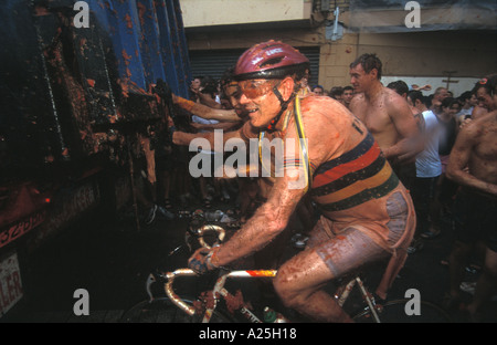 A cyclist makes his way through La tomatina festival Buñol Valencia aug 2004 Stock Photo