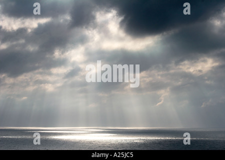 Shafts beams of sunlight coming through clouds out to sea South Africa Stock Photo