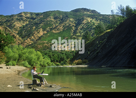 Businessman using portable table and computer with coffee cup relaxing in outdoor office Stock Photo
