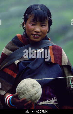 A NEPALI GIRL wearing a DOLPO BLANKET holds a ball of YARN at the upper DO TARAP VALLEY FESTIVAL DOLPO DISTRICT NEPAL Stock Photo