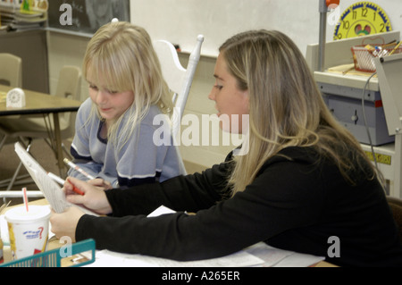 3rd grade elementary student working with teacher in an one on one situation Stock Photo
