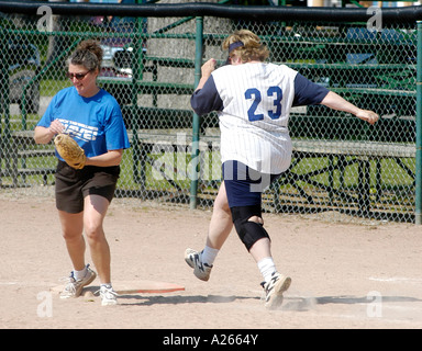 Overweight female with a brace on her injured knee running Stock Photo