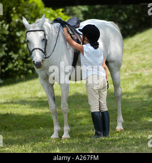 Ten year old girl preparing to ride a horse in an equestrian event Stock Photo