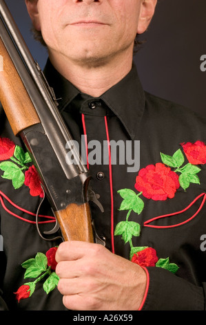 Man with cleft chin in black western shirt holding rifle Stock Photo