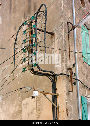 electrical installations power supply lines on facade storefront of an old house in southern France Stock Photo