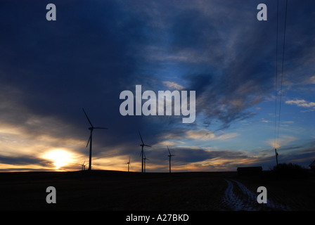 Windturbines on a praire ridge near the foothills of southern Alberta at sunrise with a few clouds and light wind Canada Stock Photo