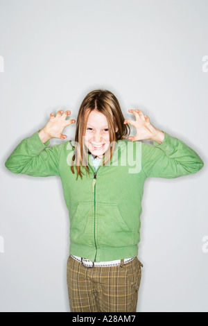 PORTRAIT OF 11 YEAR OLD GIRL WITH HANDS UP GRIMACING Stock Photo