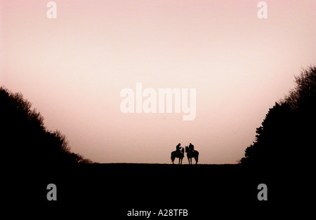 TWO RIDERS WITH THE BEAUFORT HUNT NEAR BADMINTON IN GLOUCESTERSHIRE WILTSHIRE STOP TO LIGHT CIGARETTES 15 JAN 2005 Stock Photo