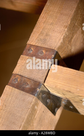 BUILDING AN EXTENSION TWO JOISTS SECURED WITH A STEEL JOIST HANGER Stock Photo