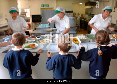 SCHOOLCHILDREN WAITING TO BE SERVED BY A DINNER LADIES WITH THE NEW HEALTHY SCHOOL DINNERS SWINDON UK Stock Photo