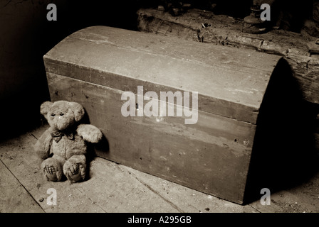 Teddy Bear and an Old Chest in the Dusty Attic Space of an Old House Stock Photo