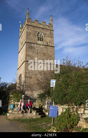 south west coast path walkers waiting for bus sat on steps of Parish Church of St Senara Zennor village Penwith Cornwall uk Stock Photo