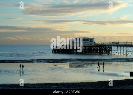 The meeting. Silhouette of  two approaching groups of people on the beach at Worthing, West Sussex uk Stock Photo