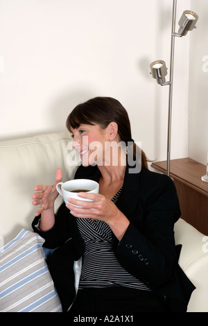 young woman in conversation having coffee chatting laughing smiling Stock Photo
