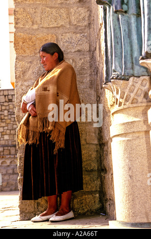 Woman standing outside of church in the Obrajes neighborhood in the Andean capital city of La Paz Bolivia Stock Photo