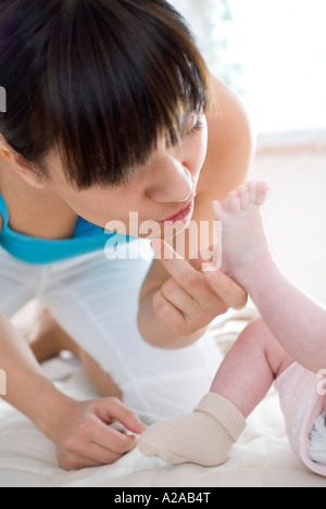 mother kissing baby's feet Stock Photo