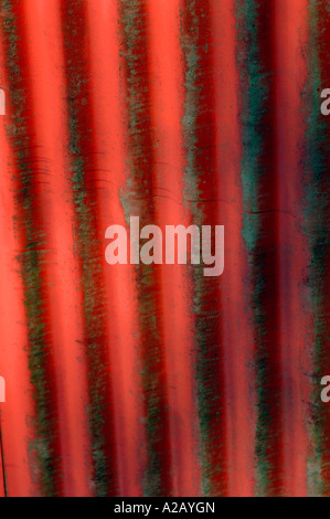 Metal Corrugated Surface,With Peeling Bright Red Orange Paint,Providing An Abstract Background. Stock Photo