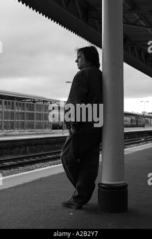 Silhouette of commuter waiting for a train at Taunton train station, England, UK Stock Photo