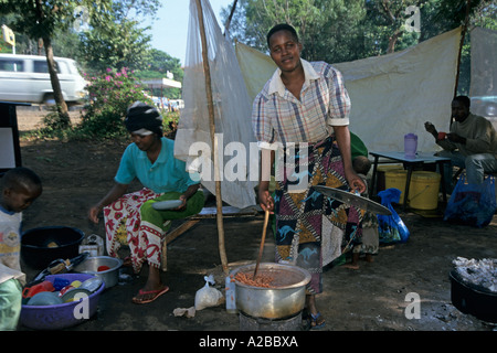 Women cooking and selling food in makeshift restaurant, Moshi, Tanzania Stock Photo