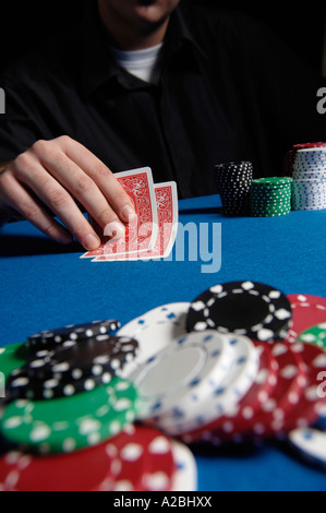 Young man looking at cards in poker game Stock Photo