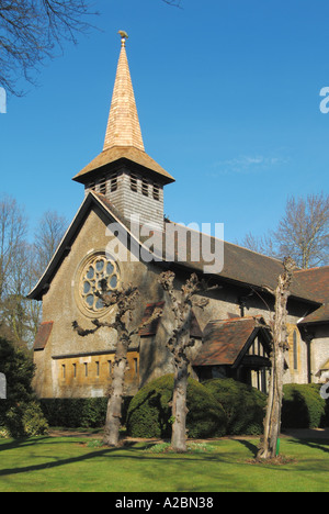 Parish church spire reclad in new timber cedar shingles before weathering to grey colour includes pollarded trees Stock Photo