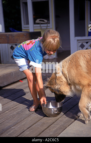 California Caucasian Vertical shot of young Caucasian 6-9 year old olds girl feeding giving  water bowl on porch deck side view profile POV  MR  © Myrleen Pearson Stock Photo