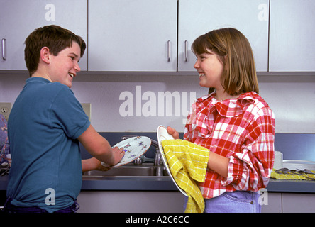 Horizontal shot of young boy and girl washing and drying dishes 10-11-12 years old year old   MR  © Myrleen Pearson Stock Photo