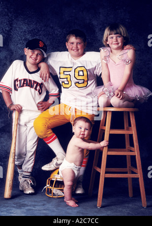 Portrait of 3 brothers and one sister They consist of a ballerina a football player baseball player and an infant Stock Photo