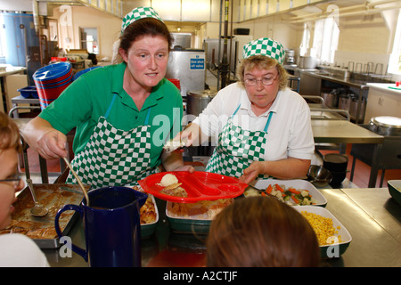 Dinner ladies serving school meals at a school in Exeter Devon UK Stock Photo