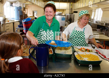 Dinner ladies serving school meals at a school in Exeter Devon UK Stock Photo
