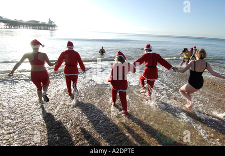 Hardy swimmers dressed in Santa suits take part in the annual Christmas Day Dip in the sea at Brighton on a sunny Xmas morning Stock Photo