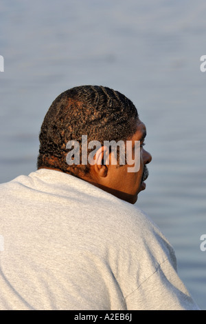 Black Adult male with the sun shining on the back of his kneck Stock Photo