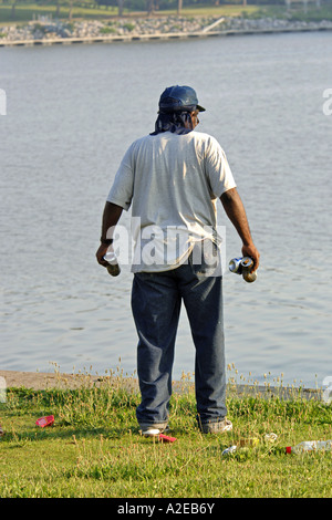 Black adult male collecting beer tins on the Maumee Riverbank in Toledo Ohio Stock Photo