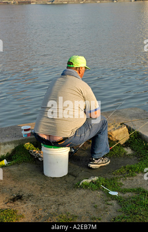 White adult male sitting fishing by the Maumee River Toledo Ohio Stock Photo