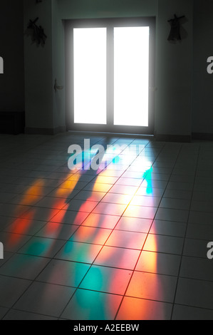 Church Door With Light From Stained Glass Window Shining On The Floor Making A Colorful Pattern In Roman Catholic Church, USA Stock Photo