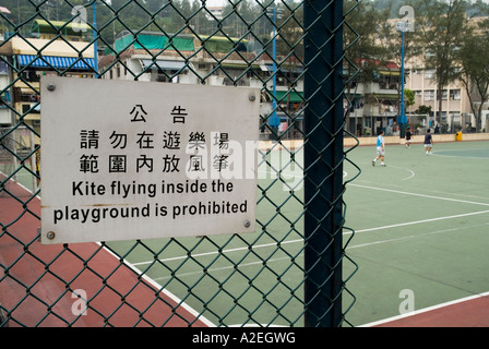 dh Multi language signs CALLIGRAPHY HONG KONG Playground kite flying prohibited sign calligraphy script english sign china Stock Photo