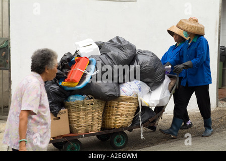 dh  CHEUNG CHAU HONG KONG Women rubbish collectors transporting garbage on trolley dustcart collection dustbin bin