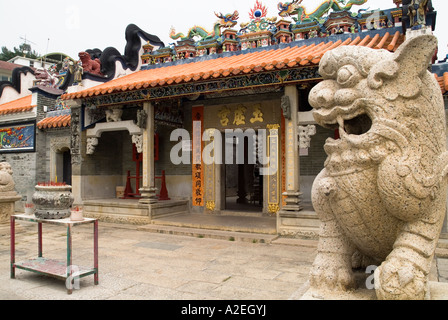 dh  CHEUNG CHAU HONG KONG Carved lion statue standing guard outside temple front entrance door