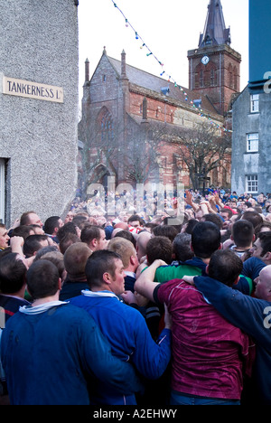 dh New Years day KIRKWALL ORKNEY Pack of Ba players and St Magnus Cathedral ball game football street people scotland