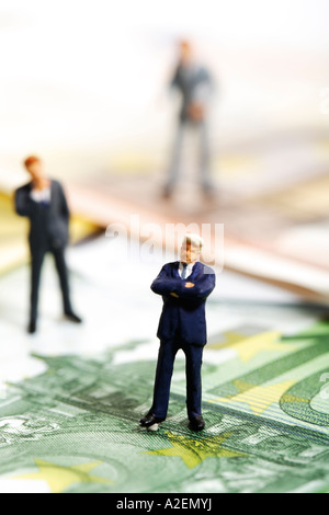 Figurines standing on Euro banknotes